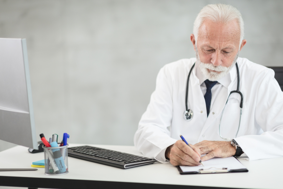 A clinician writing at a desk